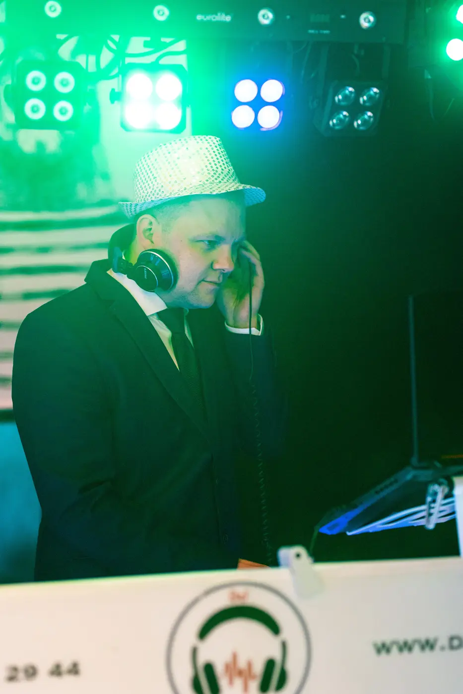 DJ Yugeen mit Kopfhörer am Pult im grünen Bühnenlicht