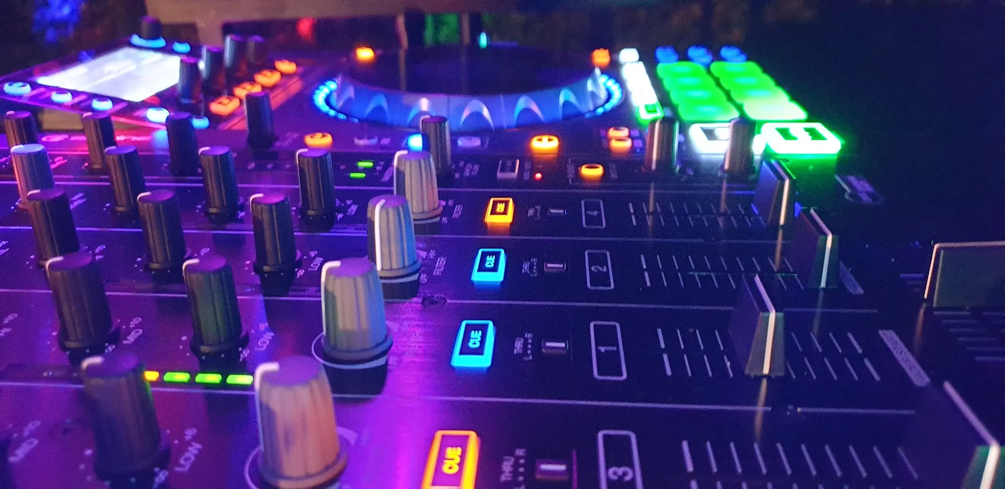 Beleuchtetes DJ-Mischpult mit Reglern und Fadern während der Feier